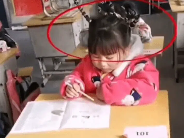 Cô bé tiểu học ngồi làm bài thi, mọi chuyện rất bình thường cho đến khi nhìn lên mái tóc, cô giáo phải thốt lên: Mẹ con bá đạo quá!