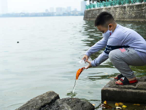 Ảnh: Người Hà Nội thả cá chép gần 1kg tiễn ông Công, ông Táo 'về trời sớm'