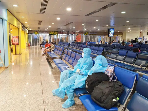 Tân Sơn Nhất vắng vẻ chiều 30 Tết, hành khách mặc đồ bảo hộ, áo mưa kín mít mệt mỏi chờ về quê