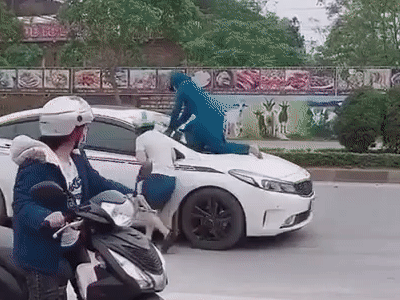 Clip: Nghi ngờ chồng chở bồ nhí, vợ liều mình đánh đu trên nóc capo, liên tục đập cửa kính gào thét