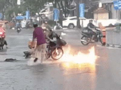 Xe máy bốc cháy giữa trời mưa lớn, hành động dập lửa của ba người đàn ông gây tranh cãi