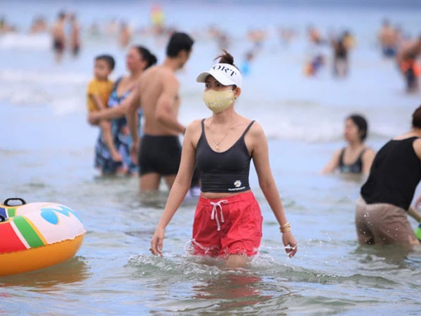 Nhiều người dân và du khách đeo khẩu trang khi tắm biển Đà Nẵng