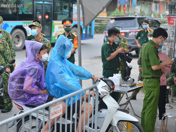 Ảnh: Người dân Thường Tín mặc áo mưa, áo bảo hộ vào khu cách ly