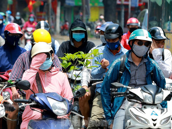 Người dân trùm kín, vất vả di chuyển dưới cái nắng gắt đầu hè