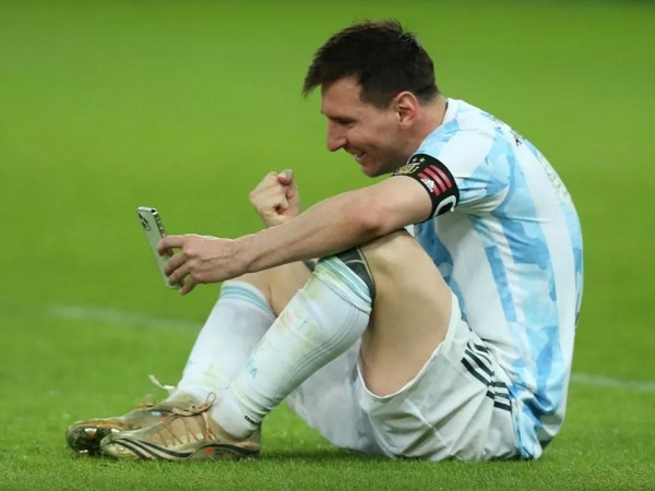 Messi ngồi bệt xuống sân, gọi video khoe huy chương với vợ con