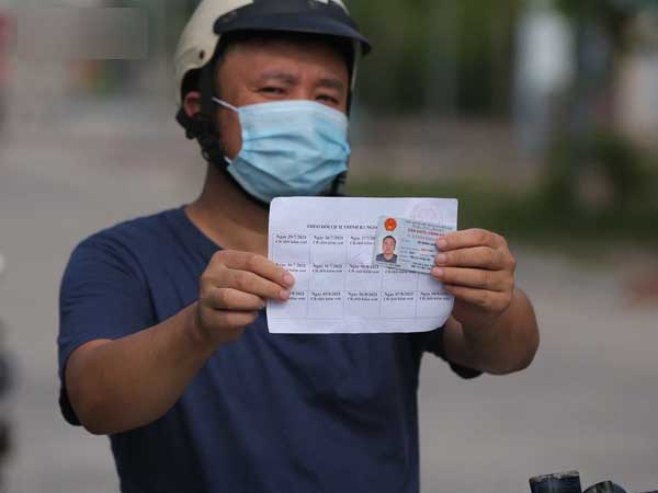 Ảnh: Phòng chống dịch Covid-19, một phường ở Hà Nội phát phiếu ra đường cho người dân 1 lần 1 ngày