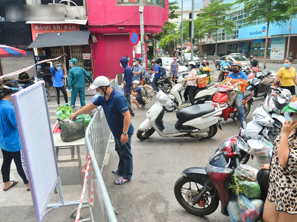 Ảnh: Người dân 'tay xách nách mang', tiếp tế nhu yếu phẩm vào 2 phường bị cách ly ở trung tâm Hà Nội