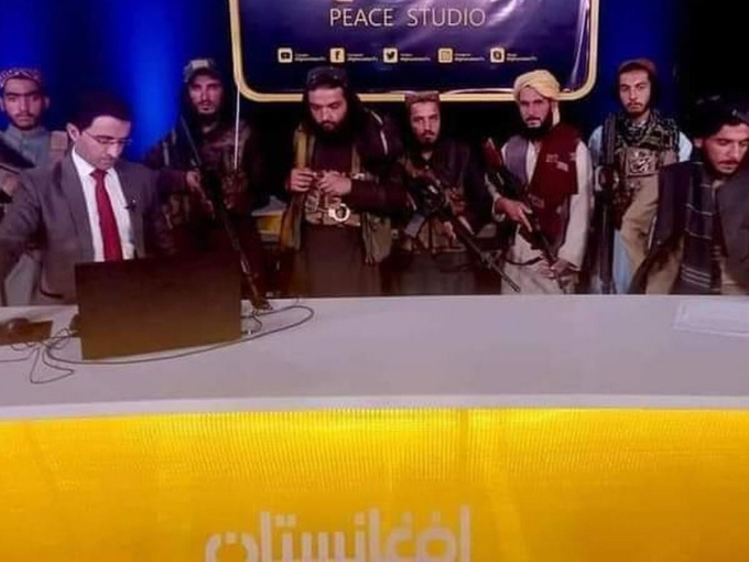 Biên tập viên truyền hình Afghanistan kêu gọi người dân 'không có gì phải sợ', xung quanh là lính Taliban đứng ôm súng