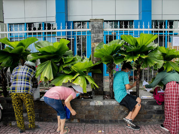 Ảnh: Cha mẹ loay hoay mua sách qua hàng rào cho con học online trong những ngày giãn cách ở TP.HCM