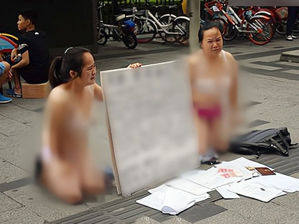 Hai người phụ nữ bán khỏa thân, quỳ trên phố xin tiền, lý do phía sau gây bất ngờ