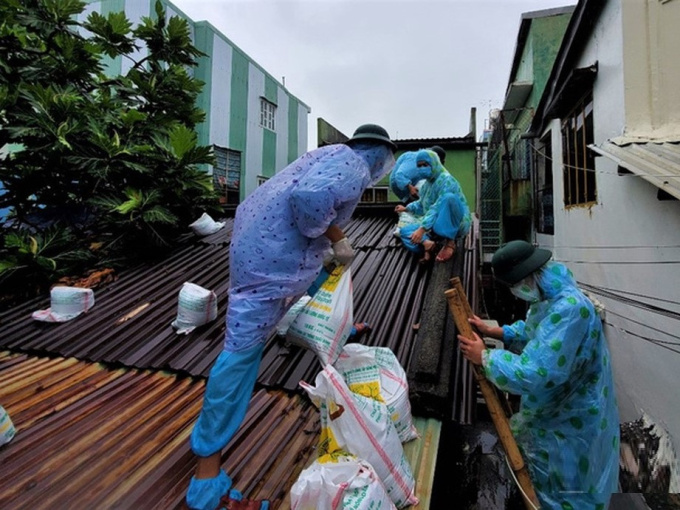 Ảnh: Bộ đội mặc đồ bảo hộ, dầm mưa vào 'vùng đỏ' giúp dân gia cố nhà chống bão số 5