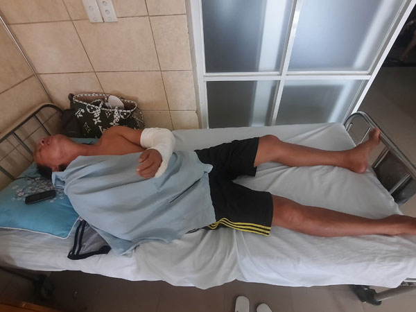 Đang ngồi trước cửa nhà, bị kề mã tấu vào cổ, chém gây thương tích