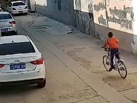 Ngậm bánh, tung tăng đạp xe rồi lao vào ô tô đỗ ven đường, hành động sau đó của cậu bé gây cười xỉu