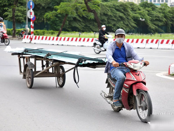 Nhan nhản xe máy cà tàng chở sắt dài chục mét 'uốn éo' trên phố Hà Nội