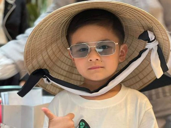 Con trai Đan Trường đội nón lá, theo mẹ đi làm từ thiện trong lần đầu về Việt Nam