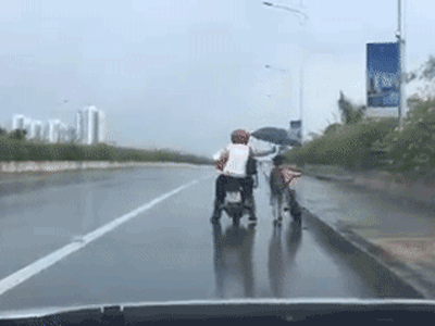 Đôi vợ chồng đội mưa che ô cho cậu bé dắt bộ xe đạp trên cầu vượt khiến cộng đồng mạng xuýt xoa tán thưởng