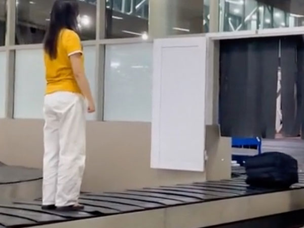 Thêm clip cô gái leo lên băng chuyền hành lý, mặc cho băng chuyền vẫn đang chạy