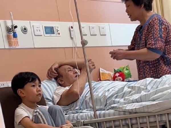 Hí hửng được ông bà đến thăm, cháu trai bất lực vì bị chiếm luôn cả giường, phải ngồi truyền nước