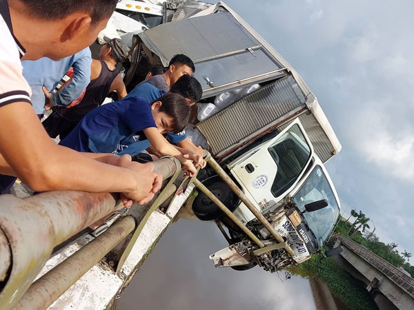 Xe tải nằm vắt vẻo giữa thành cầu sau tai nạn khiến người đi đường hoảng hốt