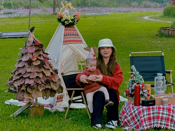 Mẹ trẻ nhặt lá bàng khô ở công viên làm cây thông Noel