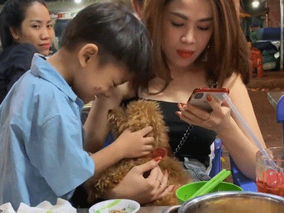 Khoảnh khắc bé trai bán hàng rong say mê âu yếm cún con và phản ứng đầy dịu dàng của vị khách nữ khiến ai nấy ấm lòng