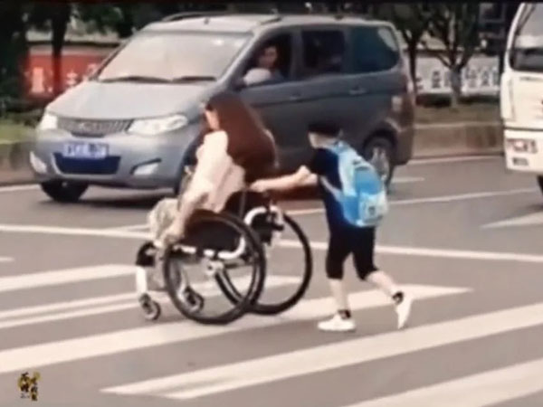 Cậu bé đẩy xe lăn đưa mẹ qua đường, cúi người 90 độ cảm ơn từng tài xế nhường đường khiến CĐM xúc động