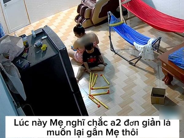 Thấy mẹ ngồi bế em, cậu bé đang chơi một mình vội quay ra ngồi tựa vào lưng mẹ, câu nói sau đó khiến người mẹ rơi nước mắt