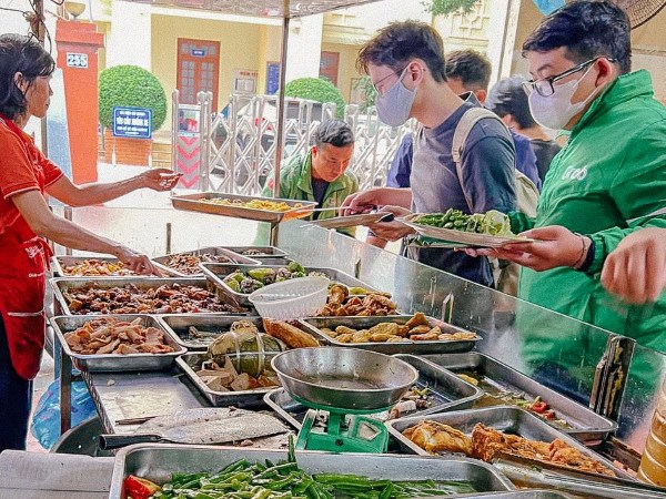 Hàng cơm trưa cân thức ăn để tính tiền ở khu văn phòng Hà Nội