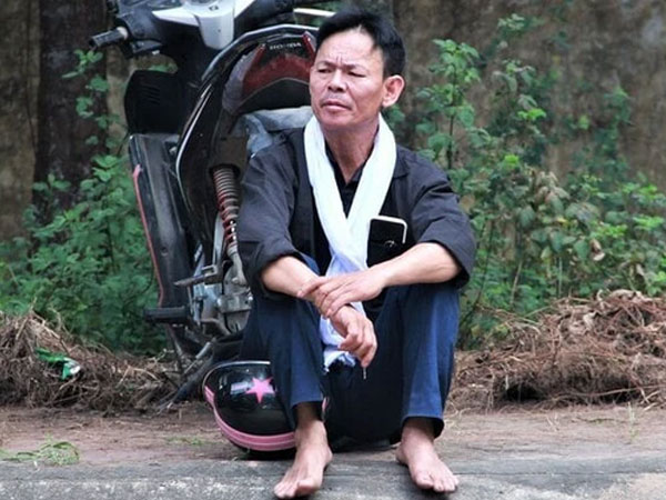 Hình ảnh người cha mặc áo đen, choàng khăn trắng đưa con đi thi tốt nghiệp gây xúc động