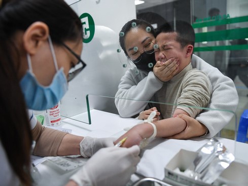 Người già, trẻ nhỏ xếp hàng chờ tiêm vắc xin phòng cúm A ở Hà Nội