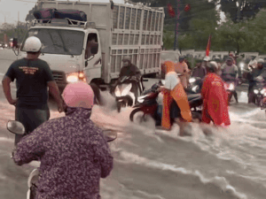 Video: Xe tải dùng thân cản dòng nước chảy mạnh, giúp người đi xe máy trên đường