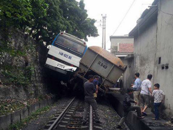 Tàu hỏa chèn xe khác chở công nhân 'lơ lửng' trên sườn đồi