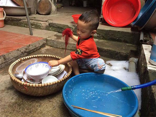 Thấy bố mẹ ăn xong không dọn, bé trai vừa rửa bát vừa nói câu khiến cả nhà 'đứng hình'