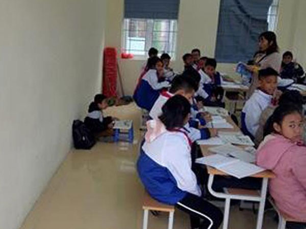 Học sinh lớp 6 bị phạt ngồi học dưới nền nhà vì không đeo khăn quàng đỏ