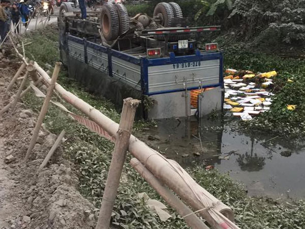 Hà Nội: Xe tải chở bia nằm ngửa dưới mương nước sau khi mất lái