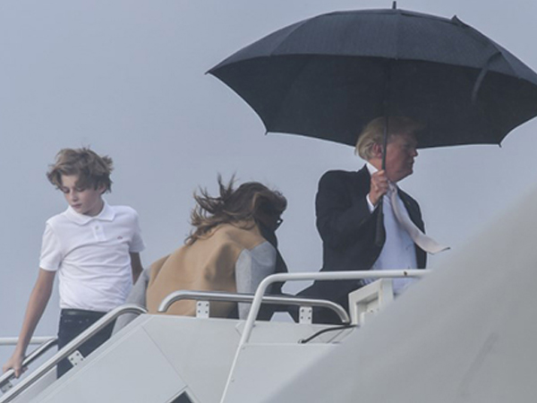 Trump che ô một mình, Melania và con trai đội mưa