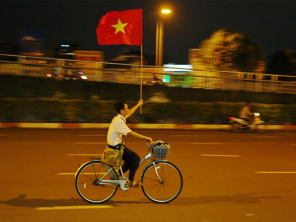 Nam sinh Sài Gòn thong dong đạp xe với lá cờ đỏ được người qua đường tặng
