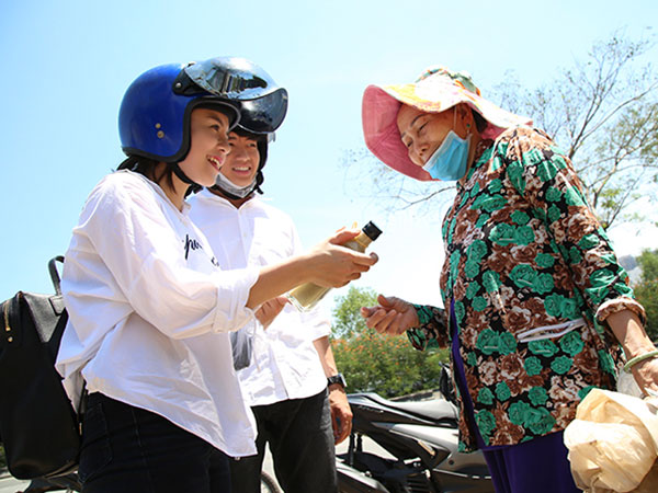 Quang Đăng, Thái Trinh chở nhau bằng xe máy đi tặng quà 8/3 cho phụ nữ nghèo