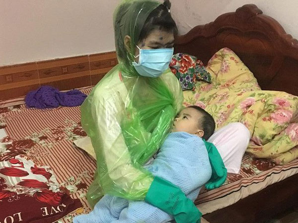 Vừa thương vừa buồn cười cảnh mẹ bị thủy đậu trùm áo mưa kín người, bịt khẩu trang như ninja vẫn ôm con vào lòng cho ti