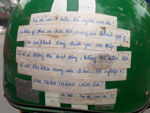Vừa ngồi lên xe, khách đã giật mình với tờ giấy dán trên mũ bảo hiểm của tài xế Grabbike