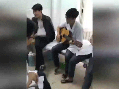 Bác sĩ thực tập đệm đàn cho bệnh nhân hát để thư giãn buổi trưa