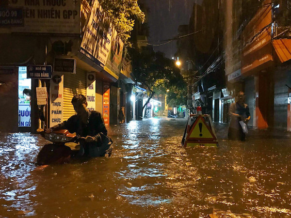 Mưa lớn trút xuống, người co chân ngồi nhậu, kẻ hì hục tát nước