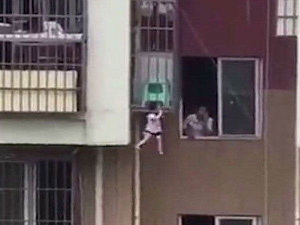 Bé 2 tuổi treo lơ lửng giữa khung sắt ở độ cao 9 m, hàng xóm 'làm ngơ'