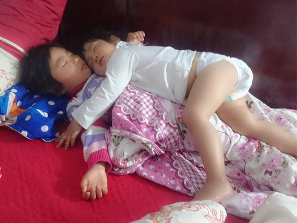 Khoảnh khắc 3 giờ sáng, hai con trứng gà trứng vịt nằm chồng lên nhau ngủ khiến trái tim ông bố đi làm về muộn tan chảy