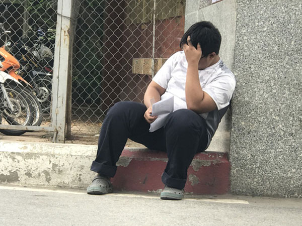 Làm bài thi kém, nam sinh ngồi ủ rũ trước cổng trường