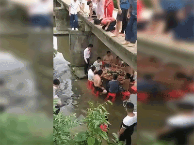Nhóm thanh niên kê bàn nhậu dưới gầm cầu, chân buông theo dòng suối để tránh nắng nóng ngày hè