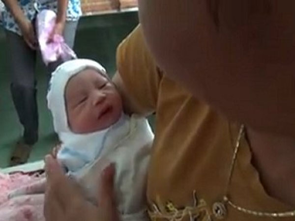Bé trai sơ sinh còn nguyên dây rốn, bọc ni lông bỏ vệ đường
