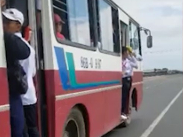 Học sinh bám trên cửa ô tô đang chạy tốc độ cao trên quốc lộ ở Bình Thuận