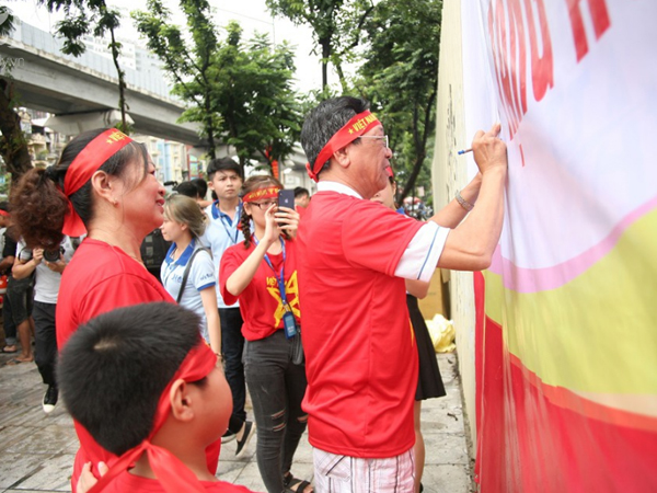 Bà bầu, trẻ nhỏ xếp hàng nhận cờ, áo, băng-rôn miễn phí trước trận Olympic Việt Nam đá bán kết ASIAD 2018