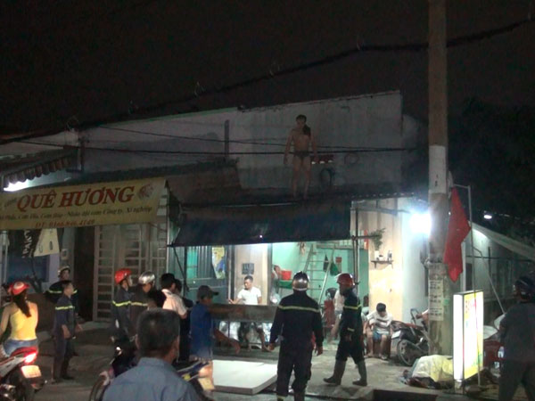 Người đàn ông nghi ngáo đá dùng kéo uy hiếp người thân, leo lên mái nhà cố thủ